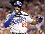  ?? AP/BILLY HURST ?? Yasiel Puigof the Los Angeles Dodgers licks his bat as he heads to the plate in St. Louis in the first inning of Friday night’s game against the St. Louis Cardinals. Puig homered in the at-bat and the Dodgers won 3-0.