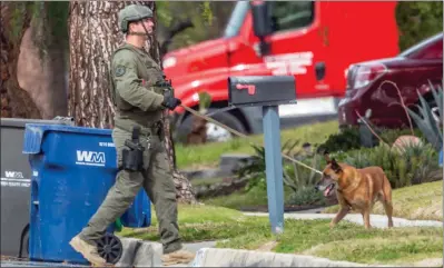  ?? Cory Rubin/The Signal ?? A Los Angeles County sheriff’s K-9 unit searches near a house for a man with a gun on Tuesday afternoon.