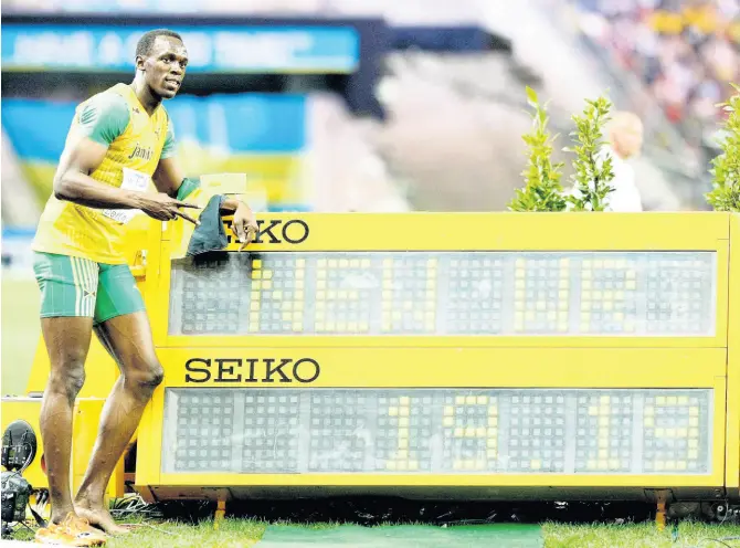  ?? AP ?? Jamaica’s Usain Bolt poses beside the timing board showing the new World record after he won the men’s 200 metres final during the IAAF World Championsh­ips in Berlin, Germany on Thursday, August 20, 2009.