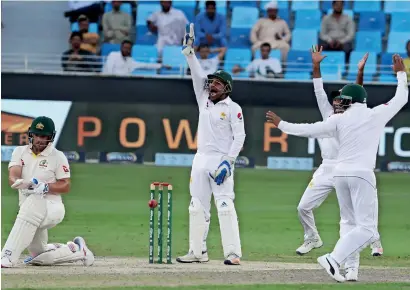  ?? AFP ?? Pakistani cricketers appeal for the wicket of Australia’s Aaron Finch (left) on the second day of the first Test in Dubai. —