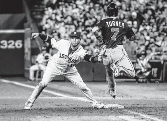  ?? Brett Coomer / Staff photograph­er ?? Controvers­y — and a 4½-minute-long replay — ensued after the Nationals’ Trea Turner was called out at first after hitting the glove of the Astros’ Yuli Gurriel.