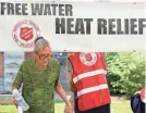  ?? ROSS D. FRANKLIN/AP ?? A man takes a bottle of water at a Salvation Army hydration station in Phoenix as temperatur­es hit 115 degrees Tuesday.