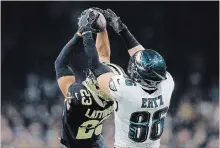  ?? JONATHAN BACHMAN GETTY IMAGES ?? Saints defender Marshon Lattimore, who had two picks, intercepts a second-quarter pass intended for the Eagles’ Zach Ertz.