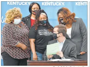  ?? Timothy D. Easley The Associated Press ?? Kentucky Gov. Andy Beshear talks with Tamika Palmer, the mother of Breonna Taylor, middle row, center, after signing a partial ban on no-knock warrants.