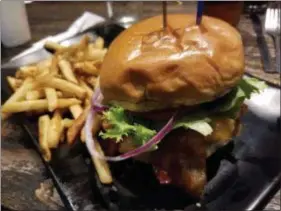  ?? MARK KOESTNER — FOR THE NEWS-HERALD ?? Burgers 2 Beer’s Nut Butter boasts cheddar and provolone cheeses, bacon, lettuce, tomato and red onion atop the patty, with peanut butter underneath it.