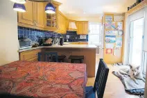  ??  ?? The kitchen’s blue backsplash contrasts beautifull­y with the warm wood.