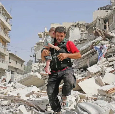  ?? AMEER ALHALBI/AFP ?? A Syrian man carries a baby after removing him from the rubble of a destroyed building following a reported airstrike in the Qatarji neighbourh­ood of the northern city of Aleppo on Wednesday.