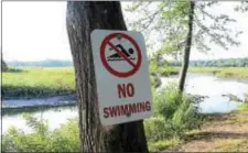  ?? GREGG SLABODA — THE TRENTONIAN ?? Shown is a “No Swimming” sign recently posted where a teenager drowned in John A. Roebling Memorial Park in Hamilton.