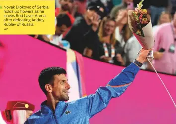  ?? AP ?? ■ Novak Djokovic of Serbia holds up flowers as he leaves Rod Laver Arena after defeating Andrey Rublev of Russia.