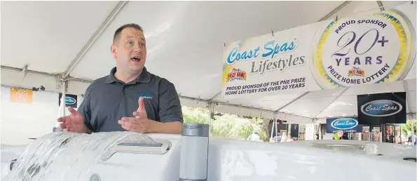  ?? GERRY KAHRMANN/PNG ?? Coast Spas sales manager Jon MacAulay extols the virtues of a hot tub — the universal symbol of relaxation — at the company’s booth. Coast Spas has been at the PNE for more than 20 years.