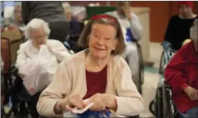  ?? PHOTO PROVIDED ?? A senior in Home Instead Senior Care’s Be a Santa to a Senior program opens a gift.