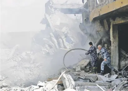  ?? Picture: AFP ?? ON TARGET. Syrian soldiers inspect the wreckage in the Barzeh district, north of Damascus, on Saturday after the US, Britain and France launched strikes against President Bashar al-Assad’s regime.