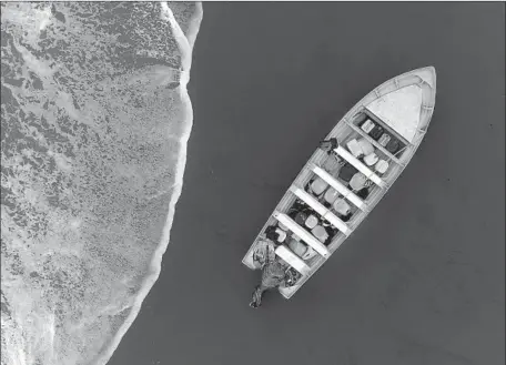  ?? Laguna Beach Police Department ?? A DRONE image of a panga-style boat that washed ashore Tuesday at Crystal Cove State Park. A nearby school was placed on lockdown during a hunt for the vessel’s occupants. At least four people were found, authoritie­s say. A similar boat washed ashore...