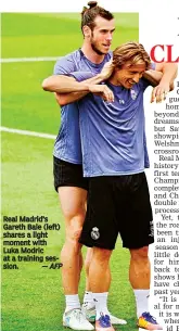  ?? — AFP ?? Real Madrid’s Gareth Bale (left) shares a light moment with Luka Modric at a training session.