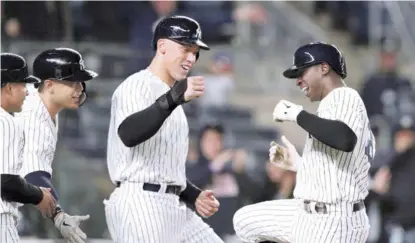  ?? AP ?? Didi Gregorius, paracorto de los Yankees es recibido en el pentágono por sus compañeros Gleyber Torres, Giancarlo Stanton y Aaron Judge, luego de que el torpedero conectara un grand slam en el partido que los Yankees apalearon 12-1 a los mellizos.