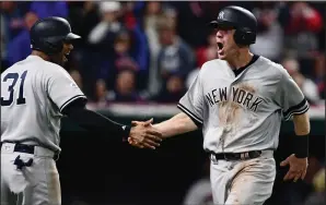  ?? AP PHOTO / DAVID DERMER ?? New York Yankees' Todd Frazier, right, celebrates with Aaron Hicks after Frazier scored in the ninth inning against the Cleveland Indians in Game 5 of a baseball American League Division Series, Wednesday in Cleveland.