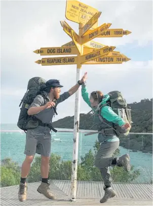  ??  ?? American park rangers Chase Lewine and Eve Barnett high-five at Bluff, at the end of their fourmonth tramp.