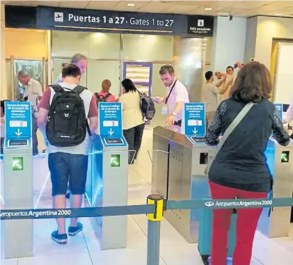  ??  ?? Lectores. Recién instalados en las terminales aéreas de Buenos Aires, chequean las tarjetas de embarque.