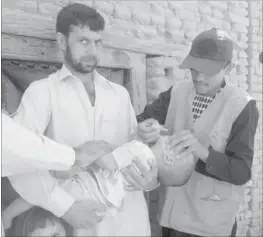  ??  ?? AFGHAN Health Ministry employees administer polio vaccine drops to a child during the second day of a vaccinatio­n campaign in Mihtarlam, capital of Laghman province yesterday. A new three-day nationwide immunisati­on campaign against polio began on June...