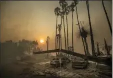  ?? NOAH BERGER — THE ASSOCIATED PRESS ?? Smoke rises behind a leveled apartment complex as a wildfire burns in Ventura on Tuesday. Over 100 structures have burned so far in Ventura County, officials said.