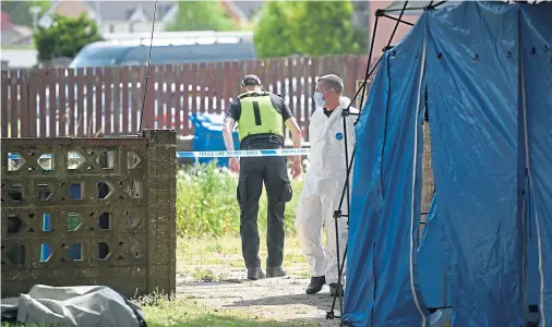  ??  ?? SCENE: Forensic officers search the exterior of the property where a blue tent was erected in the garden.