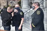  ?? PHOTO COURTESY OF MONTGOMERY COUNTY SHERIFF’S DEPARTMENT ?? New Montgomery County Sheriff’s Deputy Patrick Kivlin has his badge affixed by his father, Bucks County Sheriff’s Deputy David Kivlin as Montgomery County Sheriff Sean Kilkenny looks on.