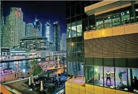  ?? [AP FILE PHOTO] ?? In this March 25, 2015, photo, men work out in a gym along the Marina waterfront in Dubai, United Arab Emirates.