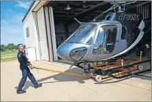  ??  ?? Sgt. Bradley Lair, an Air 1 pilot, pulls N730KC from the Oklahoma City Police Department's Air Support Unit's hangar in the Wheeler District before a flight in Oklahoma City. [NATE BILLINGS/ THE OKLAHOMAN]