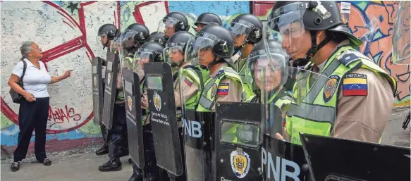  ?? PHOTOS BY MIGUEL GUTIERREZ, EUROPEAN PRESSPHOTO AGENCY ?? Police officers form a line during a rally against Venezuelan President Nicolás Maduro’s government Wednesday in Caracas. Maduro said that his government is facing “the worst aggression” to hit the country in the past decade.