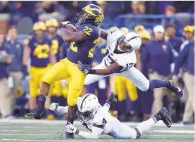  ?? PAUL SANCYA/AP ?? Michigan running back Karan Higdon (22) is tackled by Penn State safety Nick Scott (4) and Garrett Taylor (17) in the second half of Saturday’s Big Ten game in Ann Arbor, Mich.