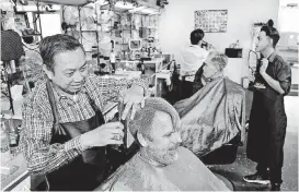  ??  ?? Ky Nguyen, left, and his sons, Anh Thy Nguyen, center, and Dieu Thy Nguyen give haircuts to customers in the family’s barber business, Hank’s Barber Shop, on Tuesday.