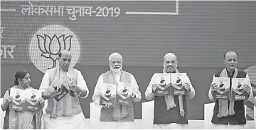  ??  ?? Modi (centre), Bharatiya Janata Party president Amit Shah (second right), Finance Minister Arun Jaitley (right), Foreign Minister Sushma Swaraj (left) and Home Affairs Minister Rajnath Singh (second left) take part in an event to launch the party’s election manifesto in New Delhi. — AFP photo
