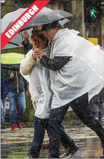  ??  ?? A couple brave the storms on the city’s Royal Mile