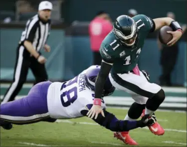  ?? MATT ROURKE — THE ASSOCIATED PRESS ?? Philadelph­ia Eagles’ Carson Wentz, right, tries to avoid Minnesota Vikings’ Linval Joseph during the first half of an NFL football game, Sunday.