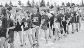  ?? [FAISAL ALI / THE OBSERVER] ?? Elmira’s St. Teresa three-pitch team brings it in after the game for high-fives on Monday at RIM Park.