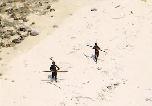 ?? INDIAN COAST GUARD ?? Primitive tribesmen are captured in this photograph on the North Sentinel Island, where members are known to shun the outside world. A record of hostility there includes the recent killing of American John Chau.