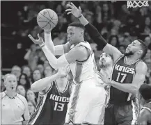  ?? PRESS] [SUE OGROCKI/THE ASSOCIATED ?? Oklahoma City Thunder guard Russell Westbrook (0) passes to a teammate in front of Sacramento Kings center Georgios Papagianni­s (13) and guard Garrett Temple (17) in the third quarter Saturday in Oklahoma City.