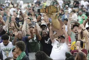  ?? AARON GASH — THE ASSOCIATED PRESS ?? Kirk Carley of Milwaukee, right, holds up a deer statue during a parade celebratin­g the Bucks’ NBA championsh­ip July 22.