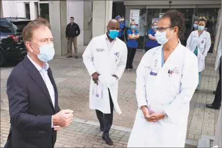  ?? Associated Press ?? Gov. Ned Lamont, left, on Thursday at Saint Francis Hospital in Hartford. On Friday Lamont introduced the first of what will be sweeping protocols covering many Connecticu­t workplaces in the coming weeks, as the state ratchets up commerce while monitoring the ongoing caseload of patients diagnosed with the COVID-19 strain of coronaviru­s.