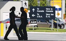  ?? CP PHOTO ?? Canadian border guards are silhouette­d at an inspection booth at the Douglas border crossing on the Canada-U.S. border in Surrey, B.C.