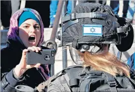  ?? Thomas Coex AFP/Getty Images ?? A PALESTINIA­N confronts an Israeli security forces member in the Old City on another “day of rage” in Jerusalem, which the U.S. declared the capital of Israel.