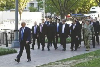  ?? ASSOCIATED PRESS ?? PRESIDENT DONALD TRUMP WALKS IN LAFAYETTE PARK to visit outside St. John’s Church across from the White House in Washington on Monday. Part of the church was set on fire during protests on Sunday night.