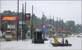  ?? LUKE SHARRETT — BLOOMBERG (VIA AP) ?? Rescuers in a boat make their way along a flooded street north of Houston on Tuesday.