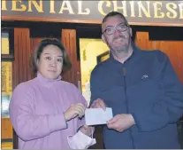  ?? Ahern) ?? LEFT: Joyce Wang (The Oriental Chinese Takeaway, Fermoy) presenting a sponsorshi­p cheque towards the ‘Northern Lights’ to committee member, Peter Roche. (Pic: John