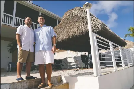  ?? (AP/Lynne Sladky) ?? Freddy Vallejo Jr. (right) poses for a photograph with his brother Joel at the family vacation home in Key Largo in the Florida Keys. Their grandfathe­r Jorge Vallejo, a retired OB-GYN, and uncle Carlos Vallejo, who practiced internal medicine, died of the coronaviru­s within weeks of one another in South Florida.