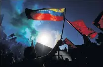  ?? PHOTOS: REUTERS ?? Supportive . . . A demonstrat­or waves a Venezuelan flag outside the US embassy in Buenos Aires during a rally in support of Venezuelan president Nicolas Maduro, in Argentina, yesterday.