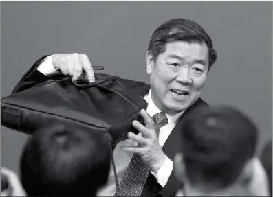  ??  ?? He Lifeng, director of the National Developmen­t and Reform Commission prepares to leave after a press conference on the sidelines of the National People’s Congress at the media center in Beijing on Monday. He, the head of China’s top economic planning...