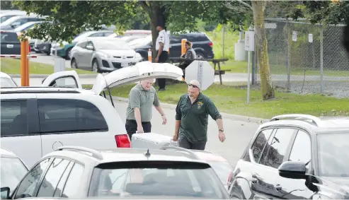  ?? PETER J THOMPSON / NATIONAL POST ?? Ministry of the Environmen­t and Climate Change investigat­ors, foreground, at Volkswagen headquarte­rs in Ajax, Ont. on Tuesday. Informatio­n to obtain the search warrant, which includes details of what the investigat­ors were seeking, is sealed to the...