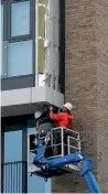  ?? Reuters ?? Workers remove cladding from a residentia­l apartment in the Wythenshaw­e area of Manchester. —