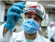  ?? AFP ?? A medical worker checks blood donated from a person who recovered from COVID-19, at the National Blood Transfusio­n Center in Cairo.